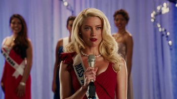 Movie still from “Machete Kills” (2013), directed by Robert Rodriguez – A woman in a red dress is holding a microphone; Close Up shot, Over the shoulder angle
