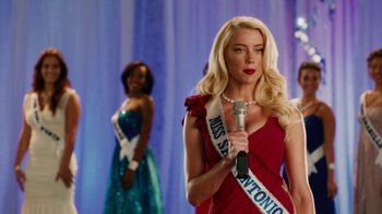 Movie still from “Machete Kills” (2013), directed by Robert Rodriguez – A woman in a red dress is holding a microphone; Medium shot, Over the shoulder angle