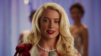 Movie still from “Machete Kills” (2013), directed by Robert Rodriguez – A woman with long blonde hair wearing a necklace and red lipstick; Close Up shot, Over the shoulder angle