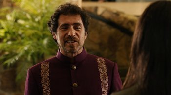 Movie still from “Machete Kills” (2013), directed by Robert Rodriguez – A person wearing a suit; Close Up shot, Over the shoulder angle