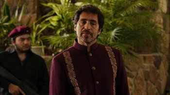Movie still from “Machete Kills” (2013), directed by Robert Rodriguez – A man with a beard wearing a purple jacket; Medium shot, Over the shoulder angle