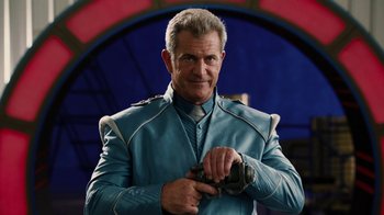 Movie still from “Machete Kills” (2013), directed by Robert Rodriguez – A man in a blue jacket holding a camera; Medium shot, Over the shoulder angle
