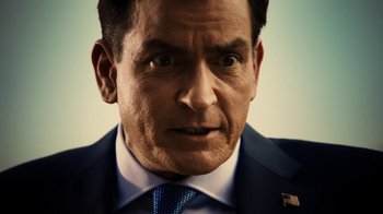 Movie still from “Machete Kills” (2013), directed by Robert Rodriguez – A person wearing a suit and tie; Close Up shot, Over the shoulder angle