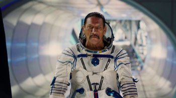 Movie still from “Machete Kills” (2013), directed by Robert Rodriguez – A man in a spacesuit standing next to a wall; Medium shot, Low angle