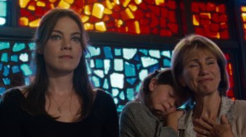 Movie still from “Machine Gun Preacher” (2011), directed by Marc Forster – Three women are sitting in front of a stained glass window; Close Up shot, Low angle