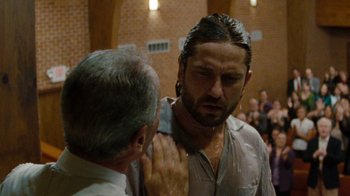 Movie still from “Machine Gun Preacher” (2011), directed by Marc Forster – A man with long hair is getting his hair cut; Close Up shot, Over the shoulder angle