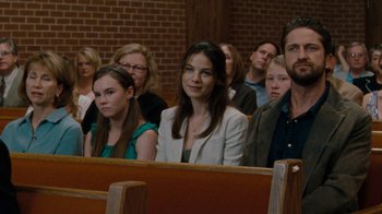 Movie still from “Machine Gun Preacher” (2011), directed by Marc Forster – A group of people sitting in pews in a church; Medium shot, Over the shoulder angle