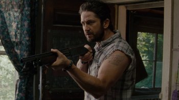 Movie still from “Machine Gun Preacher” (2011), directed by Marc Forster – A man holding a machine gun in his hand; Close Up shot, Over the shoulder angle