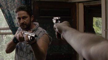 Movie still from “Machine Gun Preacher” (2011), directed by Marc Forster – A man holding a gun in front of a mirror; Close Up shot, Over the shoulder angle