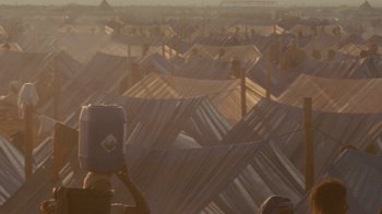 Movie still from “Machine Gun Preacher” (2011), directed by Marc Forster – A person taking a picture of a lot of roofs; Extreme Wide shot, High angle