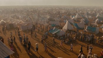 Movie still from “Machine Gun Preacher” (2011), directed by Marc Forster – A large group of people standing in a field; Extreme Wide shot, High angle