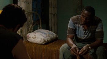 Movie still from “Machine Gun Preacher” (2011), directed by Marc Forster – A man sitting on top of a bed next to a woman; Medium shot, Over the shoulder angle