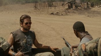 Movie still from “Machine Gun Preacher” (2011), directed by Marc Forster – A man sitting in the back of a pick - up truck; Medium shot, Over the shoulder angle