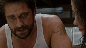 Movie still from “Machine Gun Preacher” (2011), directed by Marc Forster – A person with a tattoo on their arm; Close Up shot, High angle
