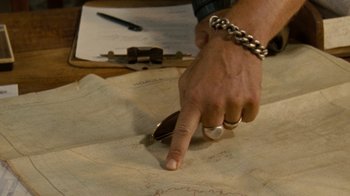 Movie still from “Machine Gun Preacher” (2011), directed by Marc Forster – A man is cutting a piece of paper with a pair of shears; Extreme Close Up shot, Overhead angle