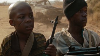 Movie still from “Machine Gun Preacher” (2011), directed by Marc Forster – Two people holding a gun in a desert area; Close Up shot, Low angle