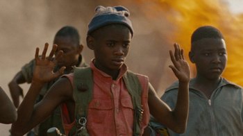 Movie still from “Machine Gun Preacher” (2011), directed by Marc Forster – A young man wearing a blue hat and a red shirt; Medium shot, Low angle