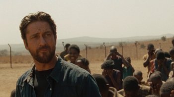 Movie still from “Machine Gun Preacher” (2011), directed by Marc Forster – A man standing in front of a group of people; Close Up shot, Over the shoulder angle