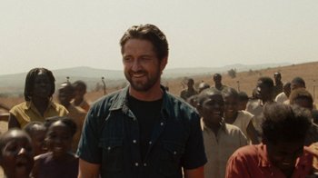 Movie still from “Machine Gun Preacher” (2011), directed by Marc Forster – A man standing in front of a group of people; Medium shot, Over the shoulder angle