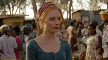 Movie still from “Machine Gun Preacher” (2011), directed by Marc Forster – A woman with red hair wearing a blue shirt and a red head scarf; Close Up shot, Over the shoulder angle