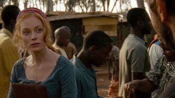 Movie still from “Machine Gun Preacher” (2011), directed by Marc Forster – A woman standing next to a group of people; Medium shot, Over the shoulder angle