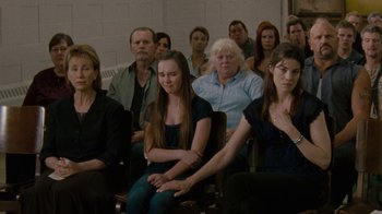 Movie still from “Machine Gun Preacher” (2011), directed by Marc Forster – A group of people sitting in front of each other in a room; Medium shot, Over the shoulder angle