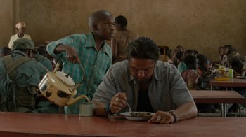 Movie still from “Machine Gun Preacher” (2011), directed by Marc Forster – Two men sitting at a table eating food; Medium shot, Over the shoulder angle
