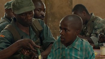 Movie still from “Machine Gun Preacher” (2011), directed by Marc Forster – A group of men standing next to each other in a room; Medium shot, Over the shoulder angle