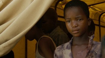 Movie still from “Machine Gun Preacher” (2011), directed by Marc Forster – A young boy standing next to another young man; Close Up shot, Over the shoulder angle