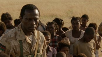 Movie still from “Machine Gun Preacher” (2011), directed by Marc Forster – A group of people standing in a field; Close Up shot, High angle
