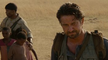 Movie still from “Machine Gun Preacher” (2011), directed by Marc Forster – A person walking in the dirt; Close Up shot, Over the shoulder angle