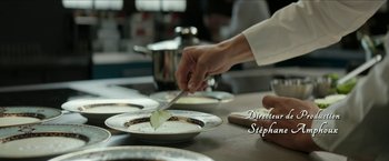 Movie still from “Madame” (2017), directed by Amanda Sthers – A person cutting a piece of food on a plate; Extreme Close Up shot, Over the shoulder angle