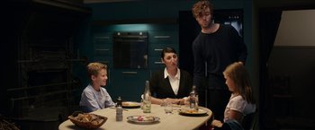 Movie still from “Madame” (2017), directed by Amanda Sthers – A group of people sitting at a table with plates of food; Medium shot, Over the shoulder angle