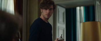 Movie still from “Madame” (2017), directed by Amanda Sthers – A young man holding a bottle in his hand; Close Up shot, Over the shoulder angle