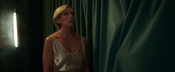 Movie still from “Madame” (2017), directed by Amanda Sthers – A woman wearing a gold dress looking up at a curtain; Medium shot, Low angle