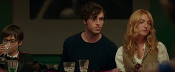 Movie still from “Madame” (2017), directed by Amanda Sthers – A man sitting in front of a group of glasses; Close Up shot, Over the shoulder angle