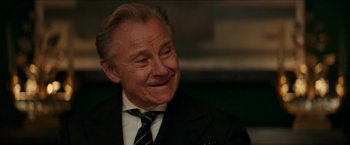 Movie still from “Madame” (2017), directed by Amanda Sthers – An older man wearing a suit and tie smiling; Close Up shot, Over the shoulder angle