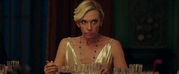 Movie still from “Madame” (2017), directed by Amanda Sthers – A woman sitting at a dinner table looking at the camera; Close Up shot, Over the shoulder angle