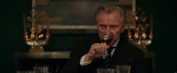 Movie still from “Madame” (2017), directed by Amanda Sthers – An older man in a suit drinking wine; Close Up shot, Over the shoulder angle