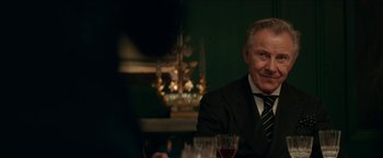 Movie still from “Madame” (2017), directed by Amanda Sthers – An older man sitting at a table with a glass of red wine; Close Up shot, Over the shoulder angle