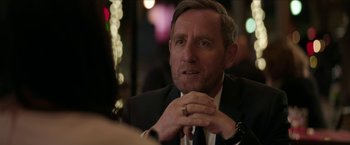 Movie still from “Madame” (2017), directed by Amanda Sthers – A person wearing a suit and tie; Close Up shot, Over the shoulder angle