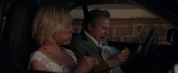 Movie still from “Madame” (2017), directed by Amanda Sthers – An older man and a younger woman sitting in a car looking at a cell phone; Medium shot, Over the shoulder angle