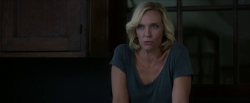 Movie still from “Madame” (2017), directed by Amanda Sthers – A woman with blonde hair sitting in a dark room; Close Up shot, Over the shoulder angle