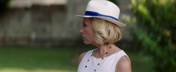 Movie still from “Madame” (2017), directed by Amanda Sthers – A woman wearing a white hat and a necklace; Close Up shot, Over the shoulder angle