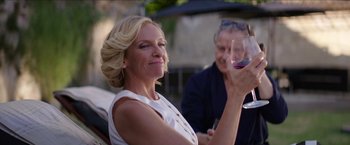 Movie still from “Madame” (2017), directed by Amanda Sthers – A woman holding a glass of red wine in front of another woman; Medium shot, Over the shoulder angle