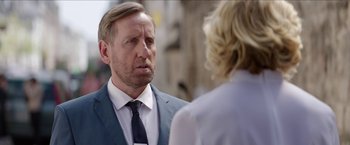 Movie still from “Madame” (2017), directed by Amanda Sthers – A man in a suit and tie talking to a woman; Close Up shot, Over the shoulder angle