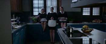 Movie still from “Madame” (2017), directed by Amanda Sthers – A group of three women sitting on top of a kitchen counter; Wide shot, High angle