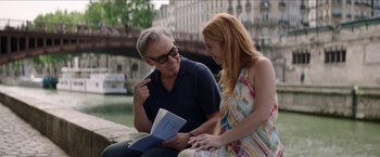 Movie still from “Madame” (2017), directed by Amanda Sthers – A man and a woman sitting next to each other on a bench; Medium shot, Over the shoulder angle
