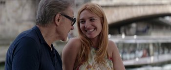 Movie still from “Madame” (2017), directed by Amanda Sthers – An older man and a younger woman smiling at each other; Close Up shot, Over the shoulder angle