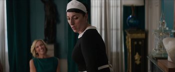 Movie still from “Madame” (2017), directed by Amanda Sthers – A woman wearing a black dress and a white hat; Medium shot, Over the shoulder angle